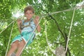 Happy child boy in adventure park in safety equipment Royalty Free Stock Photo