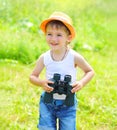 Happy child boy with binoculars outdoors in summer Royalty Free Stock Photo