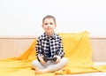 Happy child boy in checked shirt sitting on the couch with black joystick in his hands playing the video game. Playing Royalty Free Stock Photo