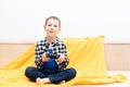 Happy child boy in checked shirt sitting on the couch with black joystick in his hands playing the video game. Playing Royalty Free Stock Photo