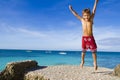 Happy child boy jumping on tropical sea background