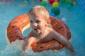 Happy child boy playing with colorful inflatable ring in outdoor swimming pool on hot summer day. Kids learn to swim. Child water Royalty Free Stock Photo