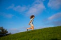 Happy child boy runs around the green field on blue sky, emotional walk on nature and happiness. Cute little boy having