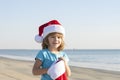 Happy child boy in Santa Claus hat on sea beach. School boy on winter vacation near sea. Happy Xmas and New Year holiday Royalty Free Stock Photo