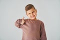 Happy child boy shows thumbs up and smiles on white background. Handsome kid posing and smiling. Royalty Free Stock Photo