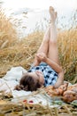 Happy child with bread in yellow autumn wheat field. A field with mature ears.girl sits on a bedspread, fresh fruits and berries, Royalty Free Stock Photo