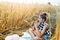 Happy child with bread in yellow autumn wheat field. A field with mature ears.girl sits on a bedspread, fresh fruits and berries, Royalty Free Stock Photo