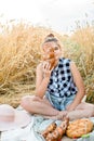 Happy child with bread in yellow autumn wheat field. A field with mature ears.girl sits on a bedspread, fresh fruits and berries, Royalty Free Stock Photo