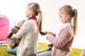 happy child brushing hair of sister while sitting on floor Royalty Free Stock Photo