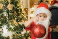 Happy child with Christmas ball. Cute little kids celebrating Christmas. Happy cute child in Santa hat with bauble have Royalty Free Stock Photo