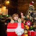 Happy child with Christmas gift. Happy kid having fun with big gift box. Christmas decorations. Wish you merry Christmas Royalty Free Stock Photo