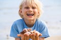 Happy child with collection of shells at beach