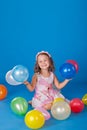 Happy child with colorful air ballons over blue