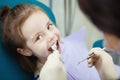 Happy child in dentist chair with napkin on chest