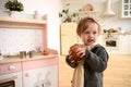 Happy child concept. Adorable baby girl with homemade cake in white designer kitchen Royalty Free Stock Photo