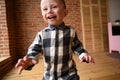 Happy child concept. Laughing toddler boy running in big empty room close up Royalty Free Stock Photo