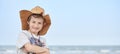 Happy child with a cowboy leather hat letting himself be photographed with the sea in the background..Close-up of a smiling child Royalty Free Stock Photo