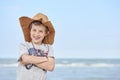 Happy child with a cowboy leather hat letting himself be photographed with the sea in the background..Close-up of a smiling child Royalty Free Stock Photo