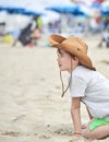 Happy child with a cowboy leather hat playing with sand..Close-up of a smiling child with cowboy hat, at the beach by the sea Royalty Free Stock Photo