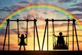 Happy child is a disabled person in a wheelchair riding an adaptive swing next to a healthy child together