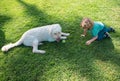 Happy child and dog on grass. Cute boy child with dog relaxing on park. Royalty Free Stock Photo