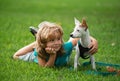 Happy child and dog hugs, lying on backyard lawn. Cute boy child with dog relaxing on park. Puppies and child in grass Royalty Free Stock Photo
