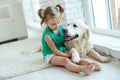 Happy child with a dog. Portrait of a girl with a pet. Labrador Retriever at home. Royalty Free Stock Photo