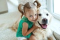 Happy child with a dog. Portrait of a girl with a pet. Labrador Retriever at home. Royalty Free Stock Photo