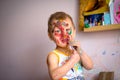 Happy child draws with colorful paints. Portrait of a child with a painted face Royalty Free Stock Photo