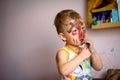 Happy child draws with colorful paints. Portrait of a child with a painted face Royalty Free Stock Photo