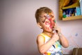 Happy child draws with colorful paints. Portrait of a child with a painted face Royalty Free Stock Photo