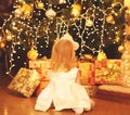 Happy child dreams near christmas tree with gifts boxes home Royalty Free Stock Photo
