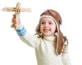 Happy child dressed pilot and playing with wooden airplane toy