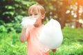 Happy child eating cotton candy. Cute little boy outdoors. Happy childhood
