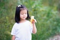 Happy child enjoy eating yellow banana. Asian girl sweet smiling Royalty Free Stock Photo