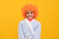 happy child in fancy orange wig hair wear home bathrobe, childhood