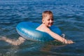 Baby floats in an inflatable round in the sea