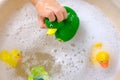 happy child, girl 3 years old plays with rubber green, yellow ducks for swimming Royalty Free Stock Photo