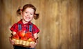 Happy child girl with basket of peaches on wooden Royalty Free Stock Photo