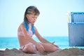 Happy child girl in bikini swimsuit playing with sand on seaside beach during summer tropical vacation Royalty Free Stock Photo