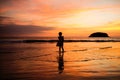 Happy child girl black silhouette on sun background. Kid having fun by water pool along sea on beach. Travel lifestyle, summer Royalty Free Stock Photo