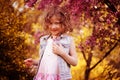 Happy child girl at blooming cherry tree in spring garden Royalty Free Stock Photo