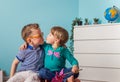 Happy child girl and boy sitting on the suitcase. Little tourists kissing and ready for travel on honey vacation Royalty Free Stock Photo