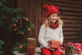 Happy child girl celebrating christmas outdoor at cozy wooden country house