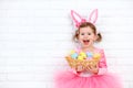Happy child girl in a costume Easter bunny rabbit with basket of Royalty Free Stock Photo