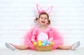 Happy child girl in a costume Easter bunny rabbit with basket of Royalty Free Stock Photo