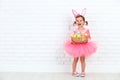 Happy child girl in a costume Easter bunny rabbit with basket of Royalty Free Stock Photo