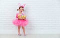 Happy child girl in a costume Easter bunny rabbit with basket of Royalty Free Stock Photo