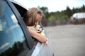 Happy child girl and dog chihuahua looking out the open car window Royalty Free Stock Photo