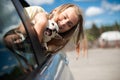 Happy child girl and dog chihuahua looking out the open car window Royalty Free Stock Photo